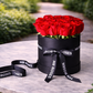 fresh red roses in an elegant black hat box